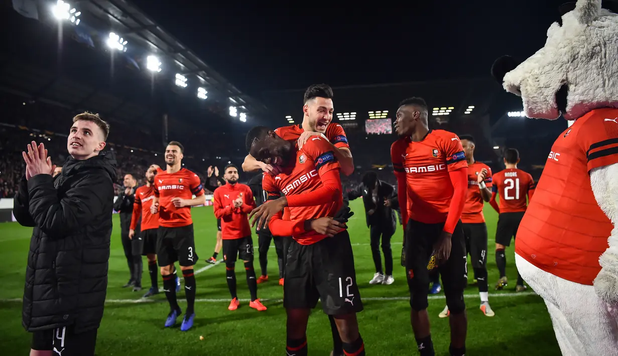 Perayaan kemenangan pemain Rennes pada leg 1, babak 16 besar Liga Europa yang berlangsung di Stadion Roazhon Park, Rennes, Jumat (8/3). Arsenal kalah 1-3 kontra Rennes. (AFP/Damien Meyer)