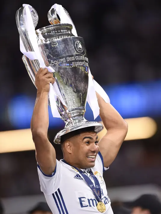 Gelandang Real Madrid Casemiro mengangkat trofi usai memenangkan pertandingan Liga Champions di Stadion Cardiff, Wales (3/6). Dalam pertandingan tersebut Casemiro berhasil mencetak satu gol ke gawang Juventus. (AFP Photo/Filippo Monteforte)