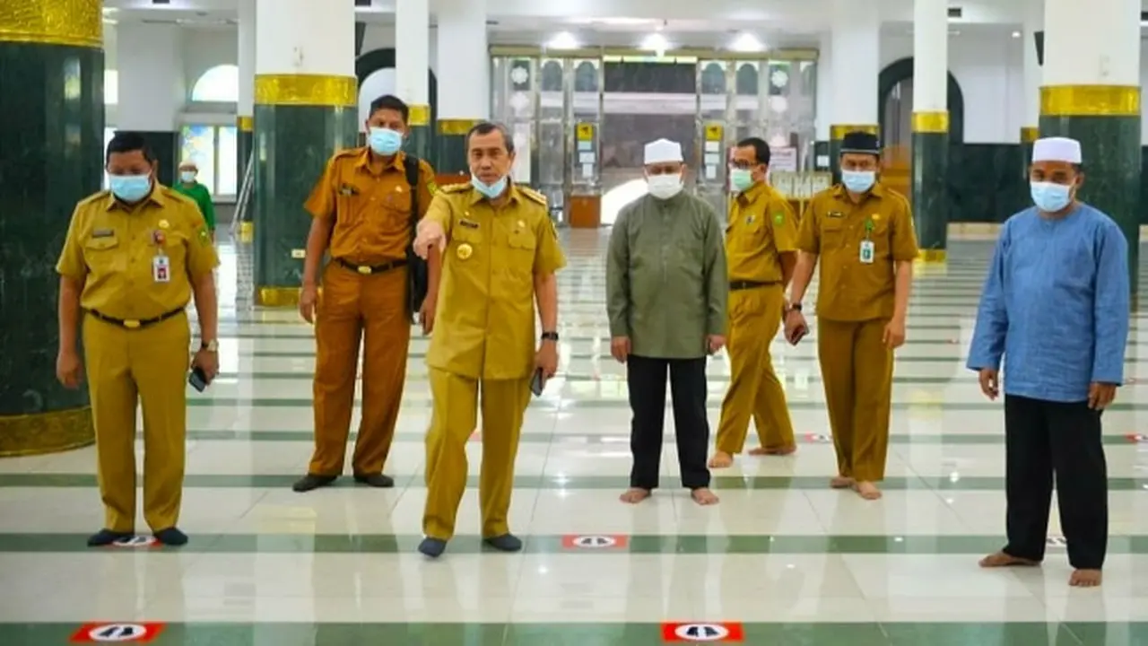 Gubernur Riau Syamsuar mengecek pengaturan jarak untuk salat berjamaah di masjid.