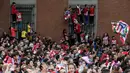 Warga Madrid tumpah ke jalan saat menyambut konvoi Atletico Madrid merayakan gelar Liga Europa di Madrid, Jumat (18/5/2018). Kota Madrid menjadi merah saat perayaan gelar juara Atletico. (AFP/Oscar Del Pozo)