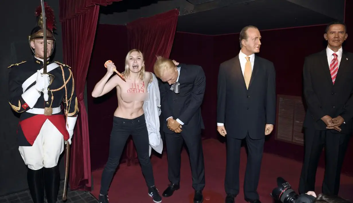 Aksi aktivis yang selalu telanjang dada ini dilakukan dengan menghancurkan patung Putin di Museum Grevin, Paris, Kamis (5/6/14). (AFP PHOTO/Eric Feferberg)