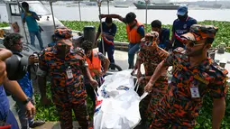 Petugas pemadam kebakaran membawa mayat korban kecelakaan feri yang ditemukan dari Sungai Shitalakshya di Narayanganj, Bangladesh (21/3/2022). Feri ML Afsar Uddin tenggelam di sungai setelah ditabrak kapal kargo. (AFP/Munir uz Zaman)