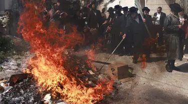 Pria Yahudi Ultra-Ortodoks membakar barang-barang beragi selama ritual Biur Chametz menjelang hari raya Paskah di Yerusalem pada tanggal 5 April 2023.