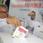 Ketua KPU Arief Budiman memasukkan surat suara saat simulasi pemungutan dan penghitungan suara Pemilu 2019 di halaman Gedung KPU, Jakarta, Selasa (12/3).  Simulasi untuk merepresentasikan pemungutan suara seperti di TPS. (Liputan6.com/Faizal Fanani)