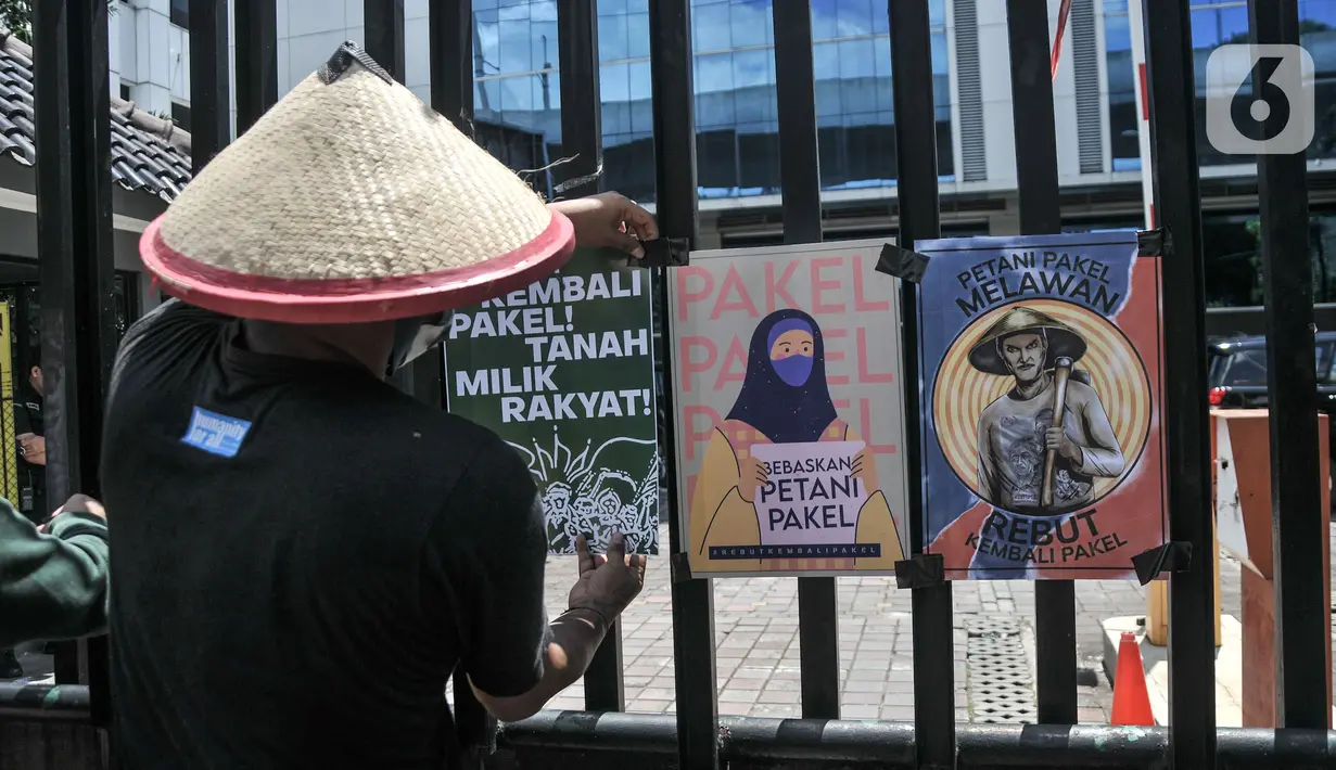 Aktivis Gerakan Rakyat untuk Kedaulatan Agraria memasang poster saat aksi mogok makan di depan Kantor Kementerian ATR/BPN, Jakarta, Senin (20/2/2023). Mereka juga menuntut Presiden Joko Widodo menyelesaikan kasus warga Pakel Banyuwangi dan memulihkan hak-hak ekonomi, sosial, budaya mereka yang terampas. (merdeka.com/Iqbal S Nugroho)