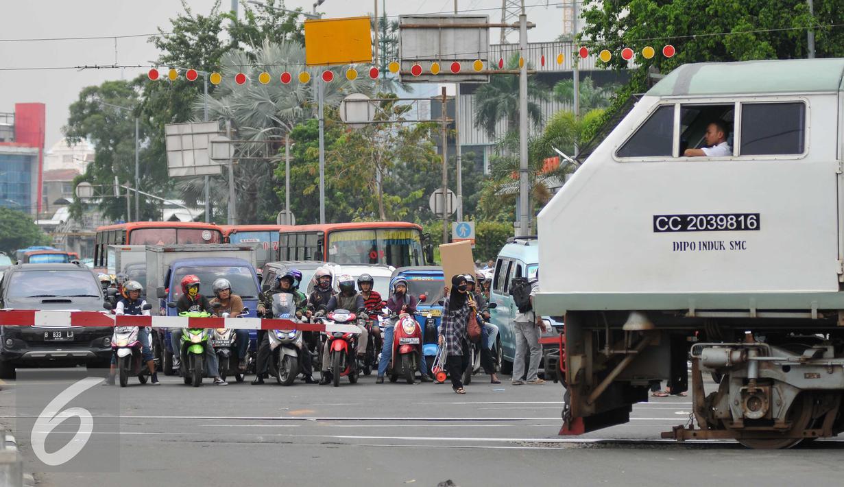  Sejumlah kendaraan menunggu kereta commuterline di perlintasan sebidang Stasiun Pasar Seen, Jakarta, (13/9). Ditjen Perkeretaapian Kemenhub akan menutup perlintasan sebidang di Jalan Letjen Soeprapto, Jakarta Pusat. (Liputan6.com/Gempur M Surya)
