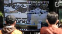 Pengunjung menyaksikan layar yang menampilkan sidang perdana Rizieq Shihab di Pengadilan Negeri Jakarta Timur, Jakarta, Selasa (16/3/2021). Massa mendatangi PN Jakarta Timur untuk menyaksikan sidang Rizieq Shihab terkait kasus kerumunan dan tes usap. (merdeka.com/Iqbal S. Nugroho)