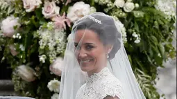 Pippa Middleton turun dari mobil setibanya di lokasi pernikahannya di sebuah gereja kecil di Inggris, Sabtu (20/5). Adik dari istri Pangeran William, Kate Middleton, itu akan menikah dengan tunangannya, James Matthew. (AP Photo/Kirsty Wigglesworth, Pool)