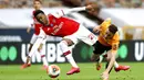 Pemain Arsenal, Joe Willock, berebut bola dengan pemain Wolverhampton Wanderers, Diogo Jota, pada laga Premier League di Stadion Molineux, Sabtu (4/6/2020). Arsenal menang dengan skor 2-0. (AP/Michael Steele)