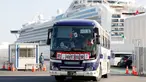 Bus dengan spanduk China bertuliskan 'Pergi, Kita Pulang!' membawa penumpang Hong Kong dari kapal pesiar Diamond Princess yang dikarantina di Yokohama, Jepang, Jumat (21/2/2020). Ratusan orang yang dinyatakan negatif virus corona (COVID-19) berangsur meninggalkan kapal. (AP Photo/Eugene Hoshiko)