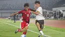 Pemain Timnas Indonesia U-17, Miraj Rizky mencoba mempertahankan bola dari rebutan pemain China U-17, Ailikamu Yilihong dalam pertandingan uji coba internasional di Indomilk Arena, Tangerang, pada Rabu (11/2/2026) malam WIB. (Bola.com/Abdul Aziz)