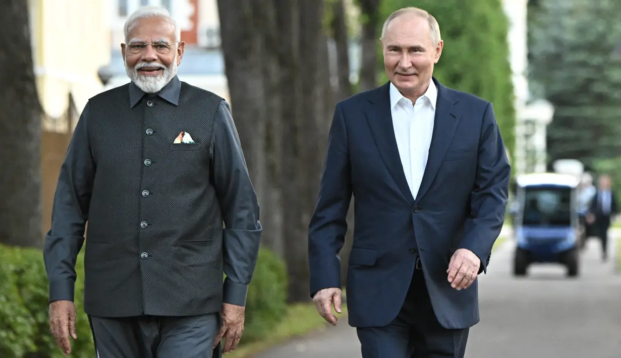 Perdana Menteri India Narendra Modi (kiri) dan Presiden Rusia Vladimir Putin berjalan saat pertemuan informal di kediaman Novo-Ogaryovo, di luar Moskow, Rusia, Senin (8/7/2024). (Sergei Bobylev, Sputnik, Kremlin Pool Photo via AP)