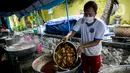 Petugas Taruna Siaga Bencana (Tagana) menggoreng daging ayam di Dapur Umum Kementerian Sosial di GOR Otista, Jakarta, Minggu (21/2/2021). Dalam sehari, petugas menyiapkan hingga 6.000 paket nasi kotak yang didistribusikan ke 11 kelurahan terdampak banjir. (Liputan6.com/Faizal Fanani)