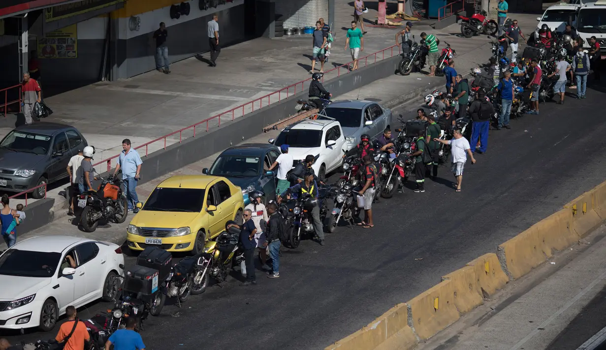 Pemandangan saat pengendara sepeda motor dan mobil mengantre BBM di salah satu SPBU di Rio de Janeiro, Brasil, Senin (28/5). Aksi mogok sopir truk menyebabkan kurangnya pasokan BBM di SPBU. (AP Photo/Leo Correa)