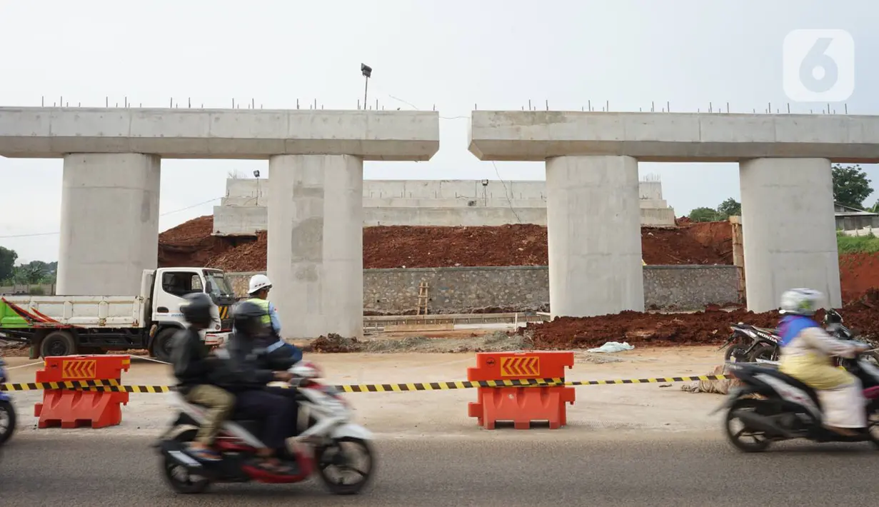 Pengendara motor melintas didekat pembangunan proyek ruas tol Depok-Antasari untuk seksi II yang menghubungkan Jalan Brigif-Sawangan di kawasan Depok, Jawa Barat, Selasa (11/2/2020). Proyek sepanjang 6,3km tersebut ditargetkan beroperasi pada triwulan I-2020. (Liputan6.com/Immanuel Antonius)