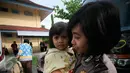 Seorang Polwan menggendong salah satu anak eks anggota Gafatar yang tiba di Penampungan Youth Center, Sleman, Yogyakarta, Jumat (29/1). Mereka sebelumnya ditampung di wisma Haji Donohudan, Boyolali untuk pendataan kependudukan (Foto: Boy Harjanto)