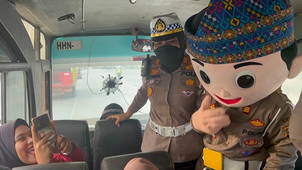 Kasat Lantas Polres Pelalawan AKP Akira Ceria masuk ke bus penumpang kampanyekan Pemilu damai.