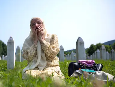Seorang wanita muslim Bosnia berduka di samping makam kerabatnya, korban genosida Srebrenica, di Memorial Center, Potocari, Bosnia-Herzegovina, Selasa (11/7/2023). Ribuan orang berkumpul di Kota Srebrenica untuk memperingati 28 tahun satu-satunya genosida yang diakui Eropa sejak Perang Dunia II. (AP Photo/Armin Durgut)