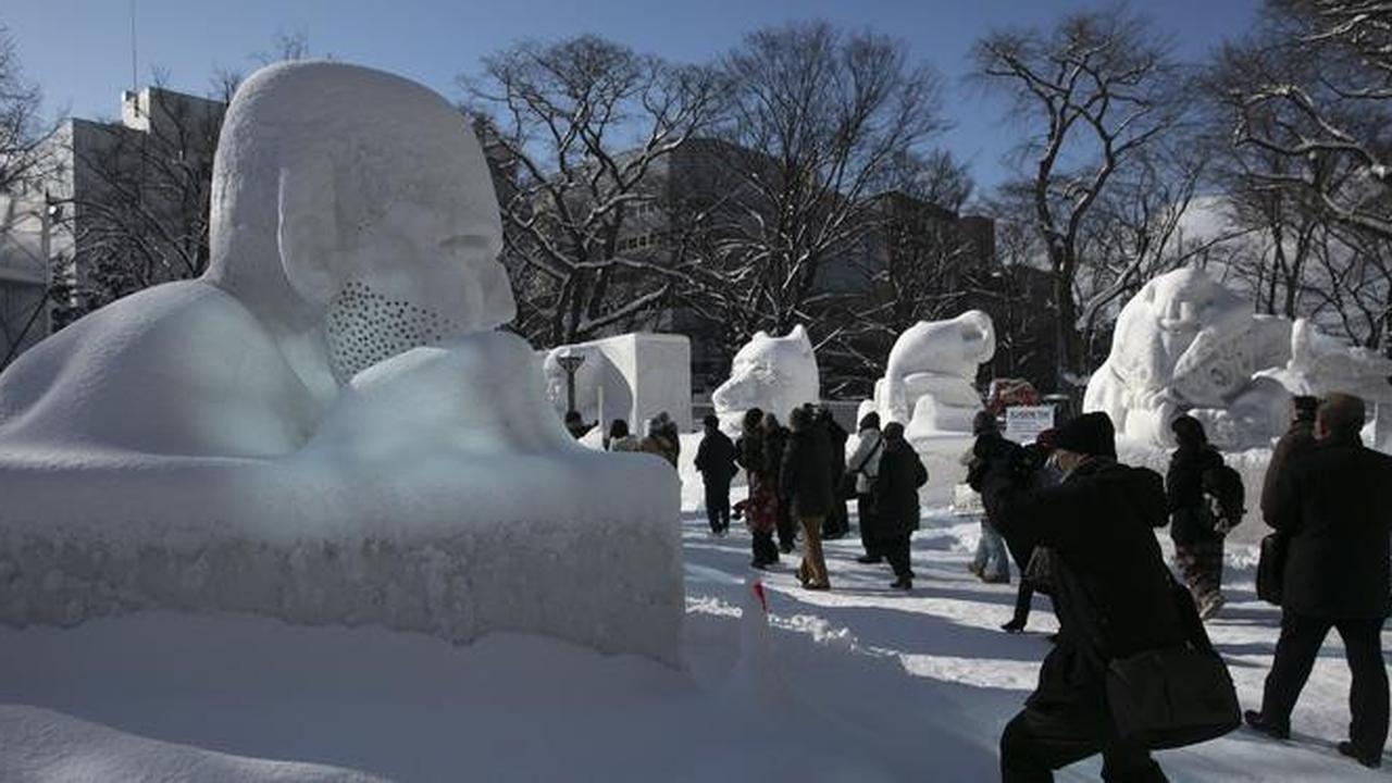 Pengunjung melihat patung-patung salju selama Festival Salju Sapporo ke-71 di Taman Odori di Sapporo, Jepang, Selasa, (4/2/2020).