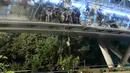 Demonstran menuruni jembatan menggunakan tali untuk melarikan diri dari Universitas Politeknik Hong Kong di Distrik Hung Hom, Hong Kong, Senin (18/11/2019). Lusinan demonstran melarikan diri dari Universitas Politeknik Hong Kong yang dikepung polisi selama berhari-hari. (AP Photo/Kin Cheung)