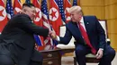 Presiden Amerika Serikat, Donald Trump berjabat tangan dengan Pemimpin Korea Utara, Kim Jong-un di zona demiliterisasi Korea (DMZ), Desa Panmunjom pada Minggu (30/6/2019).  Ini adalah kali pertama seorang presiden AS menginjakkan kaki di negara tersebut. (AP Photo/Susan Walsh)