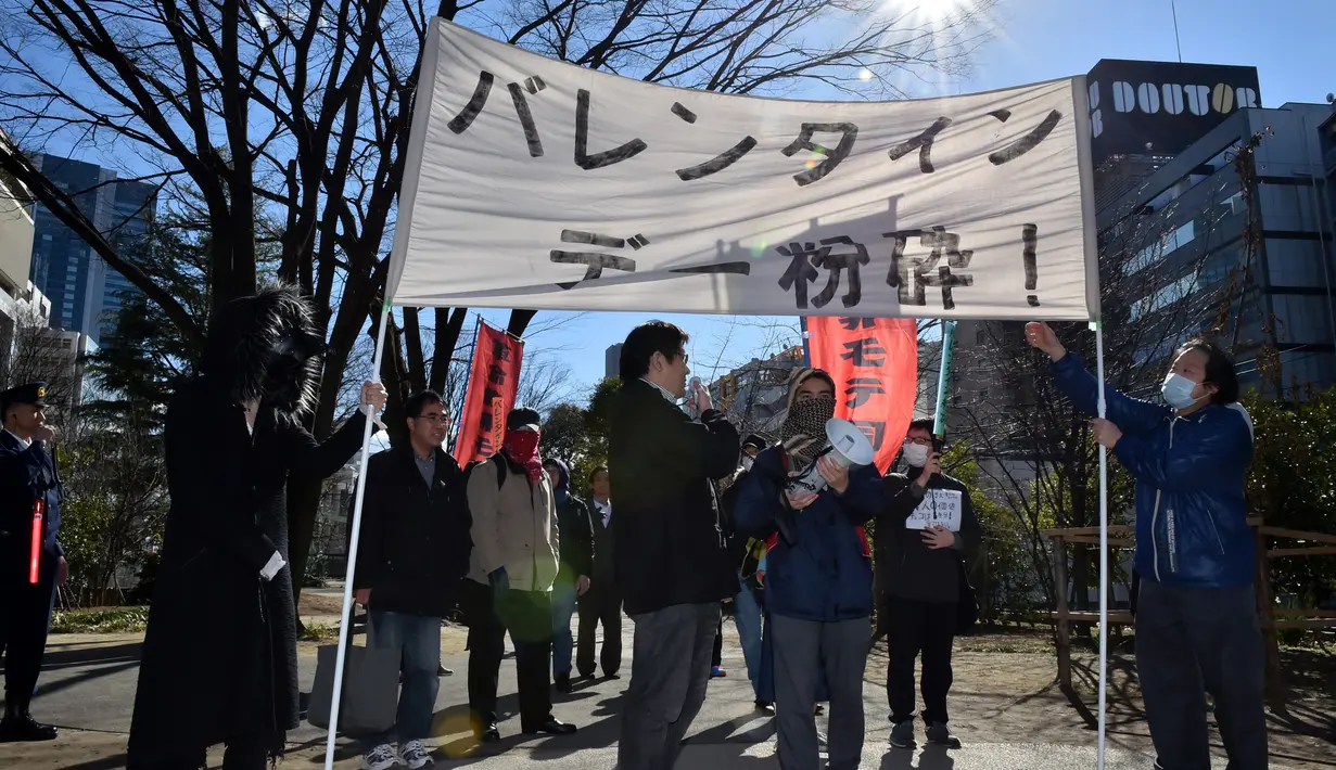 Sekelompok pria Jepang membawa spanduk turun ke jalan mengadakan demonstrasi anti-Valentine di Tokyo, Minggu (12/1). Aksi para pria anggota ‘Kakuhido’ tersebut jmenuai perhatian pejalan kaki usai mereka meneriakkan berbagai yel. (KAZUHIRO NOGI/AFP)