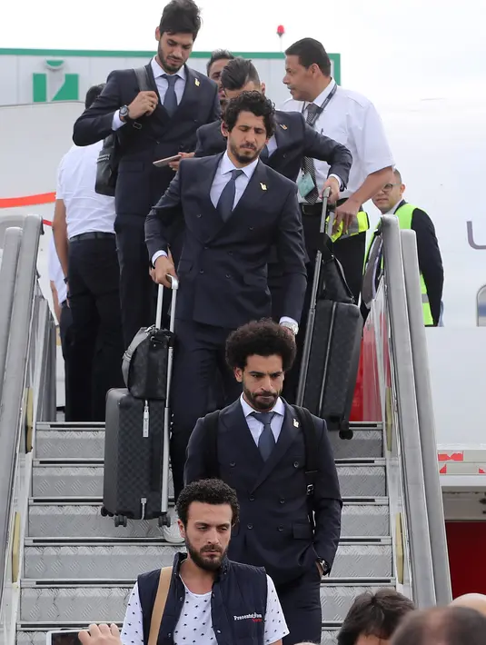 Penyerang Timnas Mesir, Mohamed Salah turun dari pesawat saat tiba di Bandar Udara Internasional Grozny, Rusia (10/6). Tim nasional sepak bola Mesir akan menggunakan Grozny sebagai base camp mereka selama Piala Dunia 2018. (AFP Photo/Karim Jaafar)