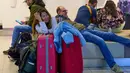Pembatalan jadwal penerbangan akibat landasan pacu yang tertutup salju dan proses de-icing pesawat yang terhambat. Tampak dalam foto, para pelancong yang terlantar menunggu di bandara Schiphol di Amsterdam, Belanda, Rabu 7 Januari 2026. (AP Photo/Peter Dejong)