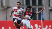 Pemain Madura United, Silvio Escobar Benitez (kiri) dan pemain Persipura Jayapura, Theo Fillo berebut bola dalam laga pekan ke-6 BRI Liga 1 2021/2022 di Stadion Wibawa Mukti, Cikarang, Minggu (03/10/2021). (Bola.com/Bagaskara Lazuardi)