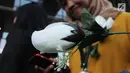 Seorang wanita menunjukkan mawar putih saat menyambut kedatangan penyidik senior KPK, Novel Baswedan di gedung KPK, Jakarta, Jumat (27/7). Novel absen 16 bulan lantaran berobat matanya setelah diserang air keras. (Merdeka.com/Dwi Narwoko)