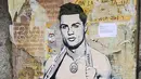 Sebuah mural dengan gambar bintang Juventus, Cristiano Ronaldo, yang terdapat di Milan, Senin (19/3). Mural berjudul Cristiano's Secret ini karya seniman Italia, TvBoy. (AFP/Miguel Medina)