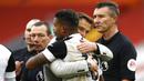 Pelatih Fulham, Scott Parker, memeluk Mario Lemina usai berhasil menaklukkan Liverpool pada laga Liga Inggris di Stadion Anfield, Minggu (7/3/2021). Fulham menang dengan skor 0-1. (Phil Noble/Pool via AP)