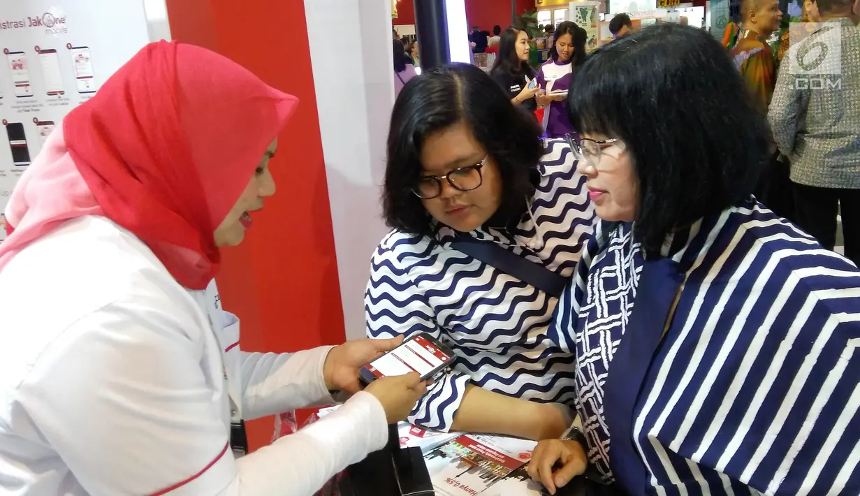 Karyawan Bank DKI menjelaskan aplikasi JakOne Mobile kepada pengunjung Pekan Raya Jakarta di Jakarta (23/5). Bank DKI turut berpartisipasi dalam PRJ sebagai alat pembayaran dengan menggunakan fitur scan to pay. (Liputan6.com/Pool/Budi)