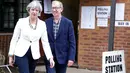 Perdana Menteri (PM) Inggris Theresa May ditemani suaminya, Phillip, meninggalkan TPS Kota Maidenhead, Kamis (8/6). Sebanyak 650 anggota parlemen Westminster akan dipilih, dengan sekitar 46,9 juta orang terdaftar untuk memilih. (AP Photo/Alastair Grant)