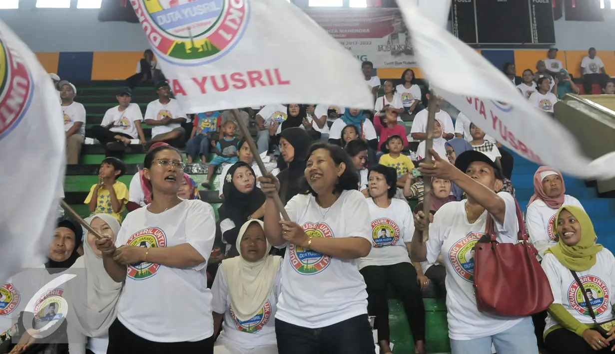 Sejumlah ibu-ibu mengibarkan bendera Duta Yusril saat acara Duta Yusril di GOR Jakarta Timur, Jumat (16/9). Bacagub DKI Jakarta, Yusril Ihza Mahendra deklarasikan relawan Duta Yusril untuk menghadapi Pilkada DKI 2017. (Liputan6.com/Yoppy Renato)