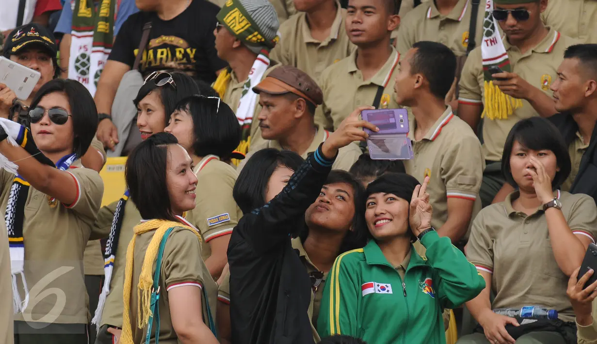 Suporter PS TNI berswadaya foto jelang menyaksikan laga antara PS TNI melawan Sriwijaya FC di Turnamen Piala Bhayangkara, Stadion Si Jalak Harupat, Bandung, Minggu (20/3/2016). PS TNI kalah 1-2 dari Sriwijaya FC. (Liputan6.com/Helmi Fithriansyah)