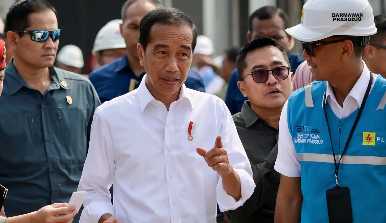 Presiden Indonesia Joko Widodo (tengah) berbincang dengan Direktur Utama PT Perusahaan Listrik Negara (Persero) Darmawan Prasodjo jelang peresmian Pembangkit Listrik Tenaga Surya (PLTS) terapung yang dapat menghasilkan 192 mega watt listrik di Waduk Cirata, Jawa Barat, pada tanggal 9 November 2023. (BAY ISMOYO/AFP)