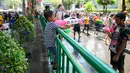 Warga saling menyemprotkan air saat merayakan Festival Songkran atau Tahun Baru Thailand di Bangkok, 14 April 2019. Setiap orang boleh menyemprotkan atau menyiram air kepada siapa pun. (Permata SAMAD/AFP)