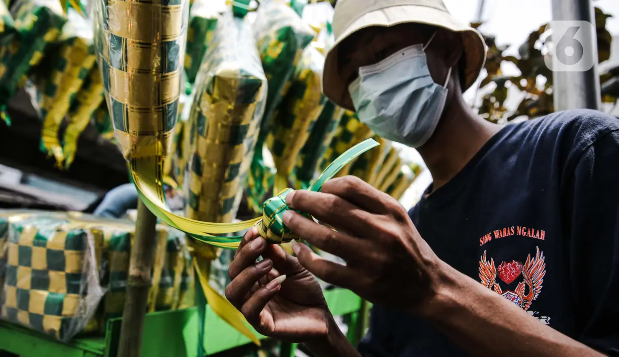 Pedagang menjalin pita untuk membuat pernak-pernik ketupat hias di Pasar Asemka, Jakarta, Selasa (4/5/2021). Pedagang mulai menjual pernak-pernik menjelang Lebaran seperti ketupat hias dengan harga mulai dari Rp15.000 hingga Rp60.000 tergantung ukuran. (Liputan6.com/Faizal Fanani)