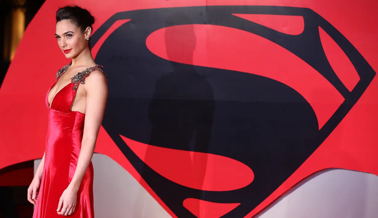 Gal Gadot, sang pemeran Wonder Women beraksi dalam balutan plunging dress warna merah dari Prada di karpet merah pemutaran film 'Batman v. Superman: Dawn of Justice' di London, Inggris, 22 Maret 2016. (JUSTIN TALLIS/AFP)
