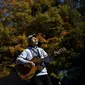 Kyochi Watanabe memainkan musik di hutan Aokigahara, dengan harapan agar tak ada lagi orang yang ingin bunuh diri karena putus asa di hutan tersebut. (AFP File)