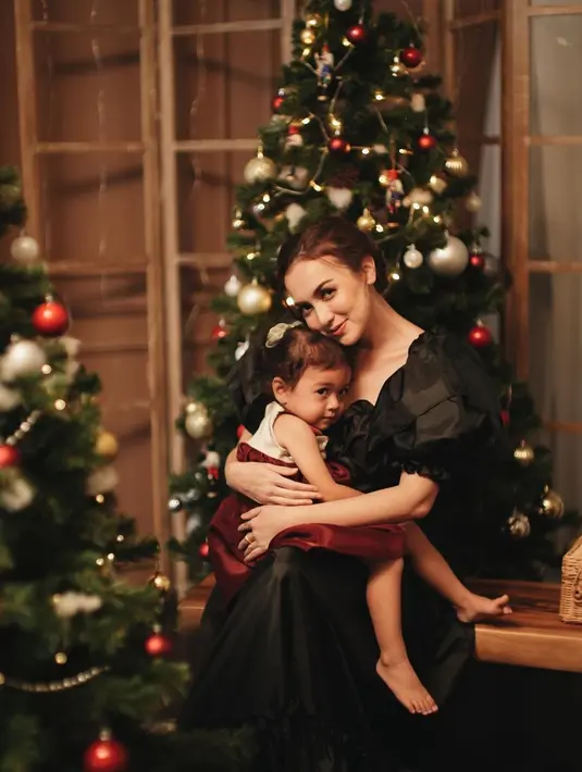 Rianti Cartwright juga tampil menawan dengan simpel dress berwarna hitam. Sedangkan sang putri tampak menggemaskan dengan dress putih dan merah dalam pangkuan sang ibu. (Liputan6.com/IG/@riantic)