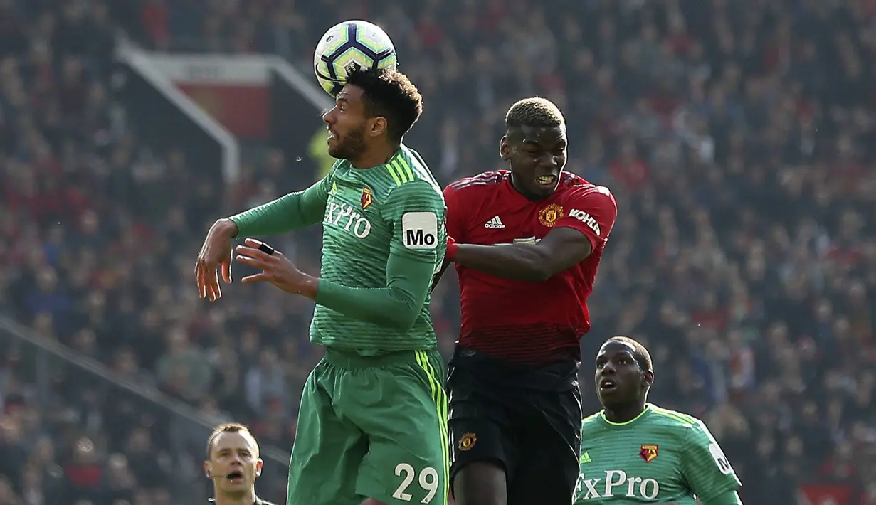 Gelandang Manchester United, Paul Pogba, duel udara dengan pemain Watford, Etienne Capoue, pada laga Premier League di Stadion Old Trafford, Sabtu (30/3). Manchester United menang 2-1 atas Watford. (AP/Martin Rickett)