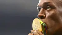  Sprinter Jamaika, Usain Bolt, mencium medali emas lari 100 m Olimpiade Rio 2016 yang diraihnya dalam final di Olympic Stadium, Rio de Janeiro, Brasil, (15/8/2016). (Reuters/Leonhard Foeger)