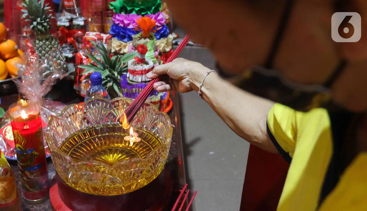Warga keturunan Tionghoa membakar dupa saat melaksanakan sembahyang malam Imlek di di Wihara Amurva Bhumi Karet, Jakarta, Sabtu (21/1/2023). Tahun Baru Imlek 2574 yang jatuh pada tahun Kelinci tersebut dimaknai menurut kepercayaan etnis Tionghoa sebagi tahun yang penuh harapan kebahagiaan, keberuntungan dan kehidupan yang lebih baik dari sebelumnya. (Liputan6.com/Herman Zakharia)