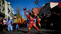 Atraksi seorang pria yang mengenakan kostum dan topeng kera saat perayaan menjelang tahun baru China di Lisbon, Portugal (21/1). Perayaan tahun baru Imlek merupakan salah satu hari besar yang dirayakan oleh kaum Tionghoa. (AFP/Patricia De Melo Moreira)