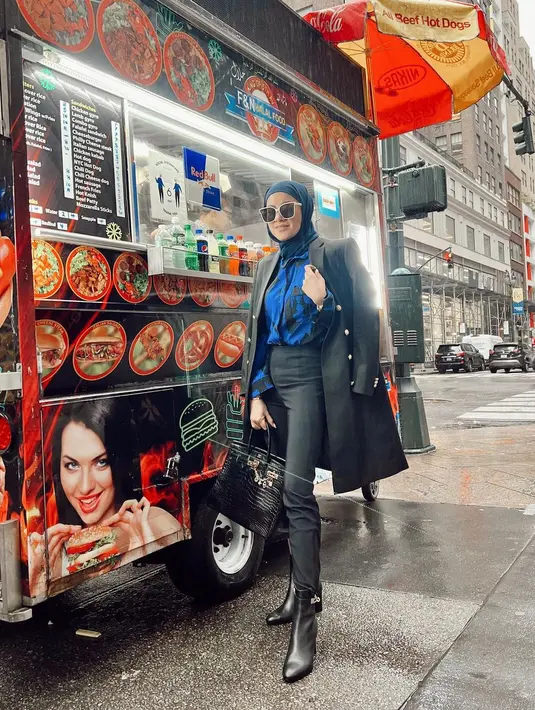 Meski bergaya di samping food truck pinggir jalan, Olla Ramlan bergaya layaknya lady boss. Mengenakan kemeja biru bermotif hitam yang dipadukan dengan skinny pants, oversized blazer, boots, dan tas Hermes kesayangannya. (instagram/ollaramlan)