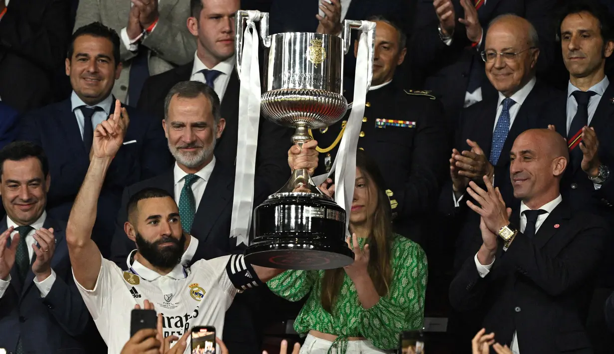 Pemain sekaligus kapten Real Madrid, Karim Benzema saat mengangkat piala Copa del Rey 2022/2023 setelah berhasil mengalahkan Osasuna dalam partai final di La Cartuja, Minggu (7/5/2023). (AFP/Javier Soriano)