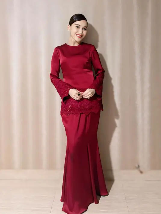 Penampilan terbarunya, Ayu mengenakan baju kurung warna merah. Dengan atasan lengan panjang yang dihiasi embroidery dan payetan di bagian lengan dan bawah baju. Dipadukan rok panjang polos model mermaid. Baju kurung buatan Yanti Adeni ini membuat Ayu tampil elegan. [@Instagram/ayutingting92].