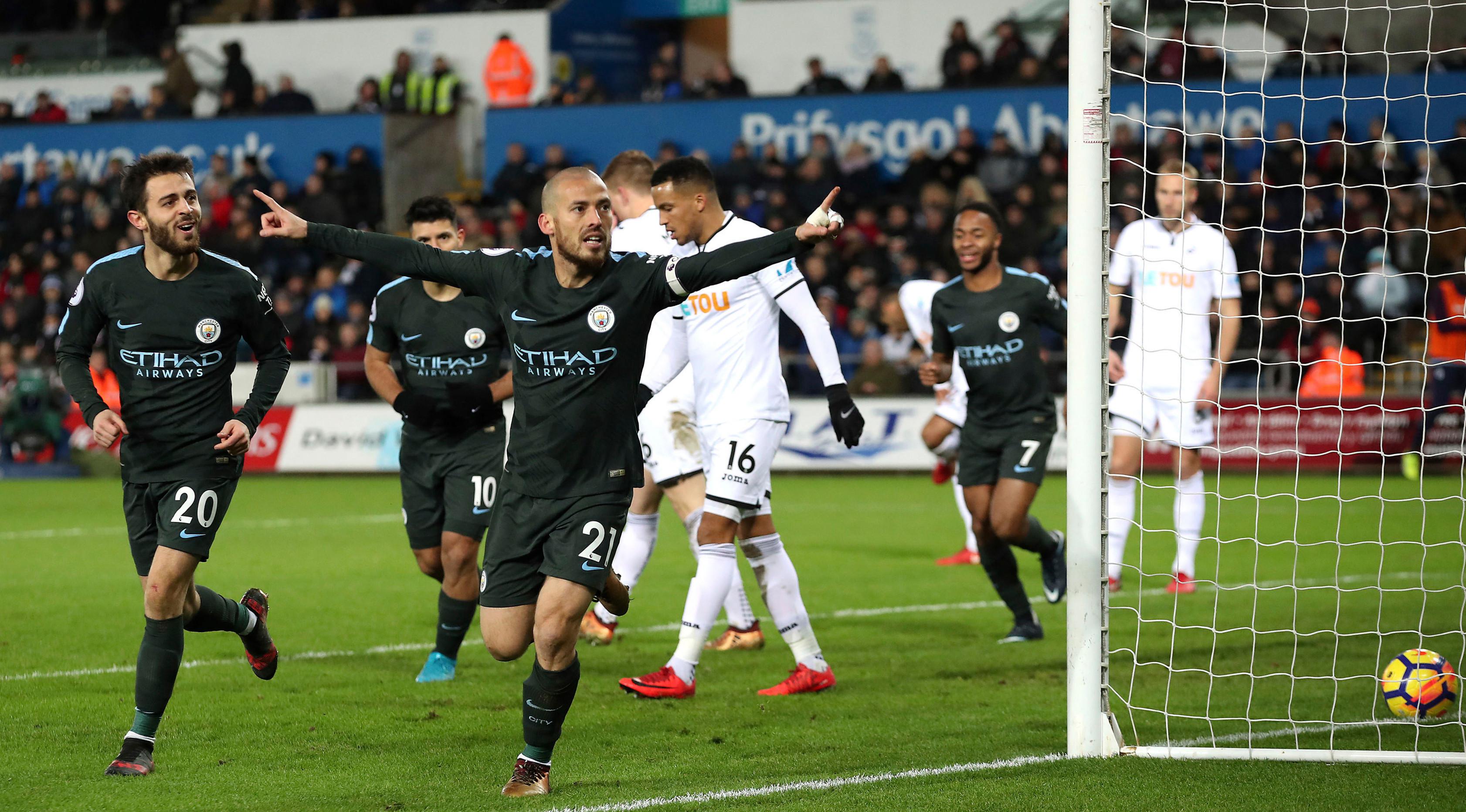 Pemain Manchester City, David Silva merayakan gol ke gawang Swansea City pada lanjutan Premier League, di Liberty Stadium, Rabu (13/12). Man City mencatatkan rekor 15 kemenangan berturut-turut usai menang dengan skor 4-0. (Nick Potts/PA via AP)